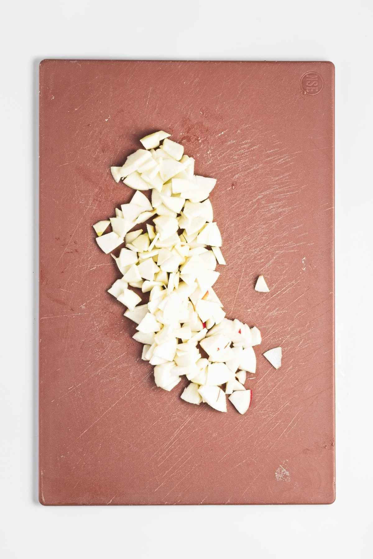 Finely diced apple pieces on a cutting board.