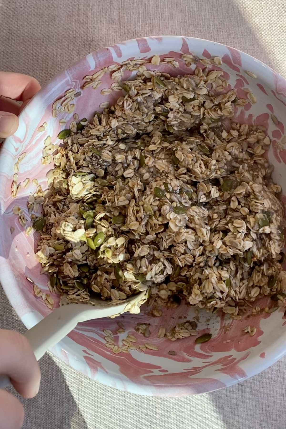 Seeded oat mixture thickened with water being stirred in a bowl.