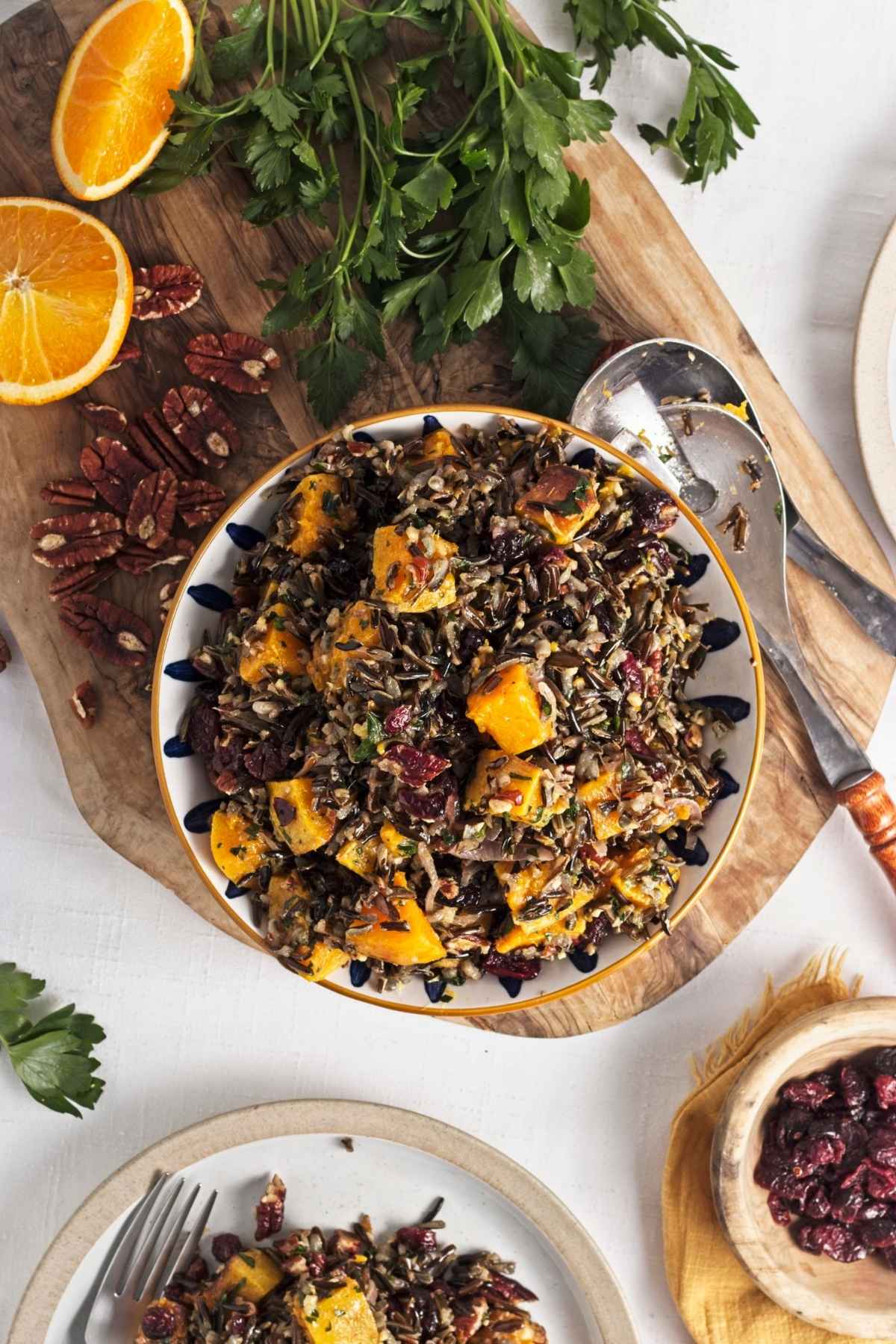 Overhead view of wild rice salad with roasted squash, cranberries, and pecans in a serving bowl.