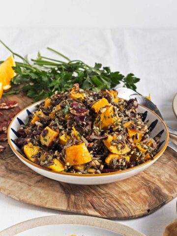 Wild rice salad with roasted butternut, cranberries, and pecans arranged in a bowl.