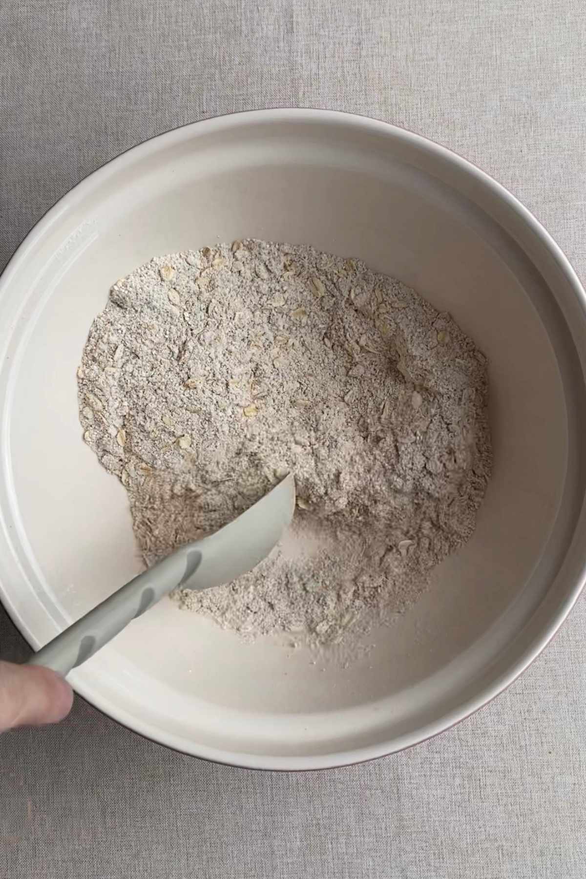 Dry ingredients for blueberry breakfast muffins mixed together in a large white bowl.