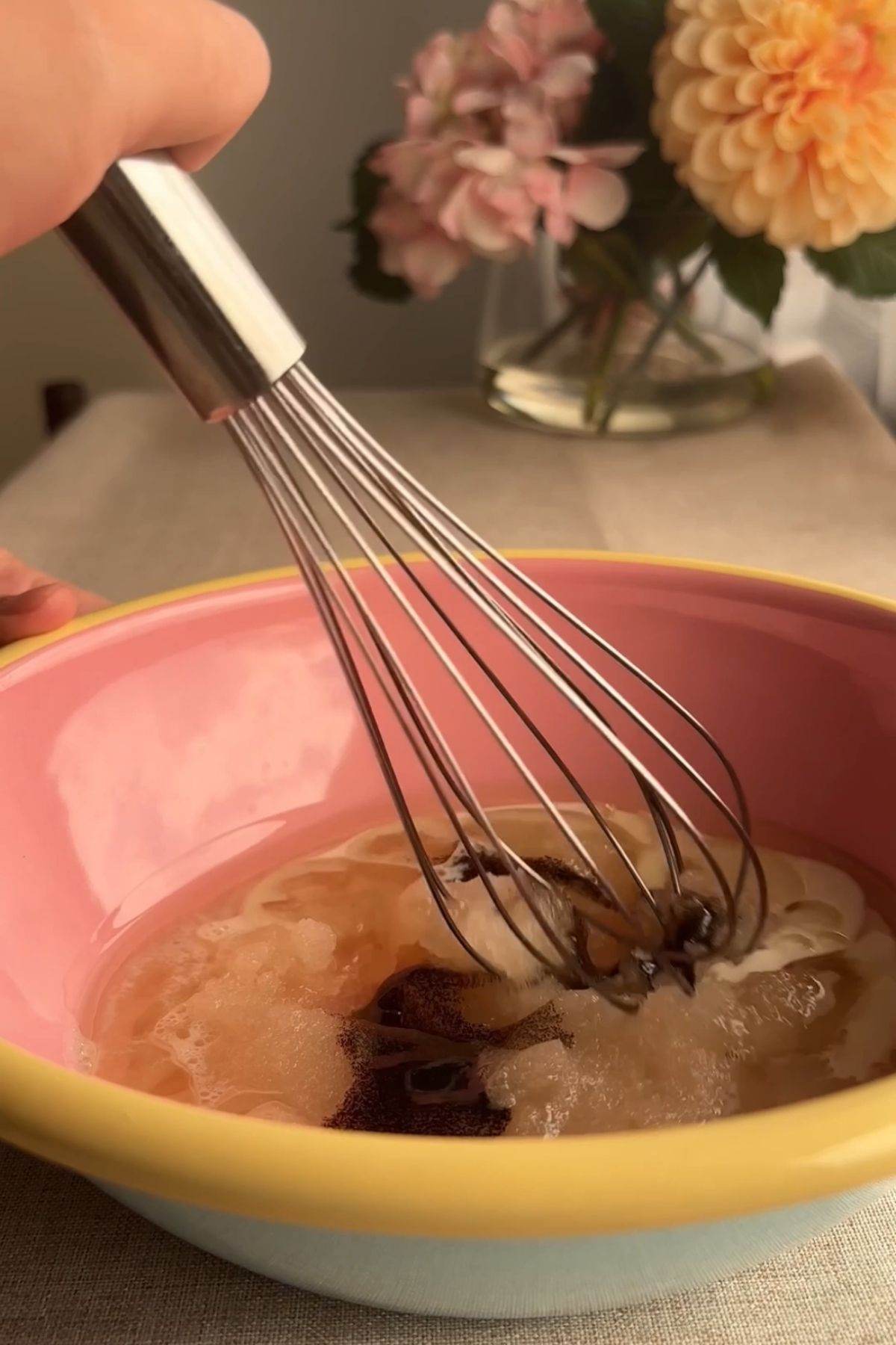 Whisking sugar, oil, milk, and vanilla together until smooth.