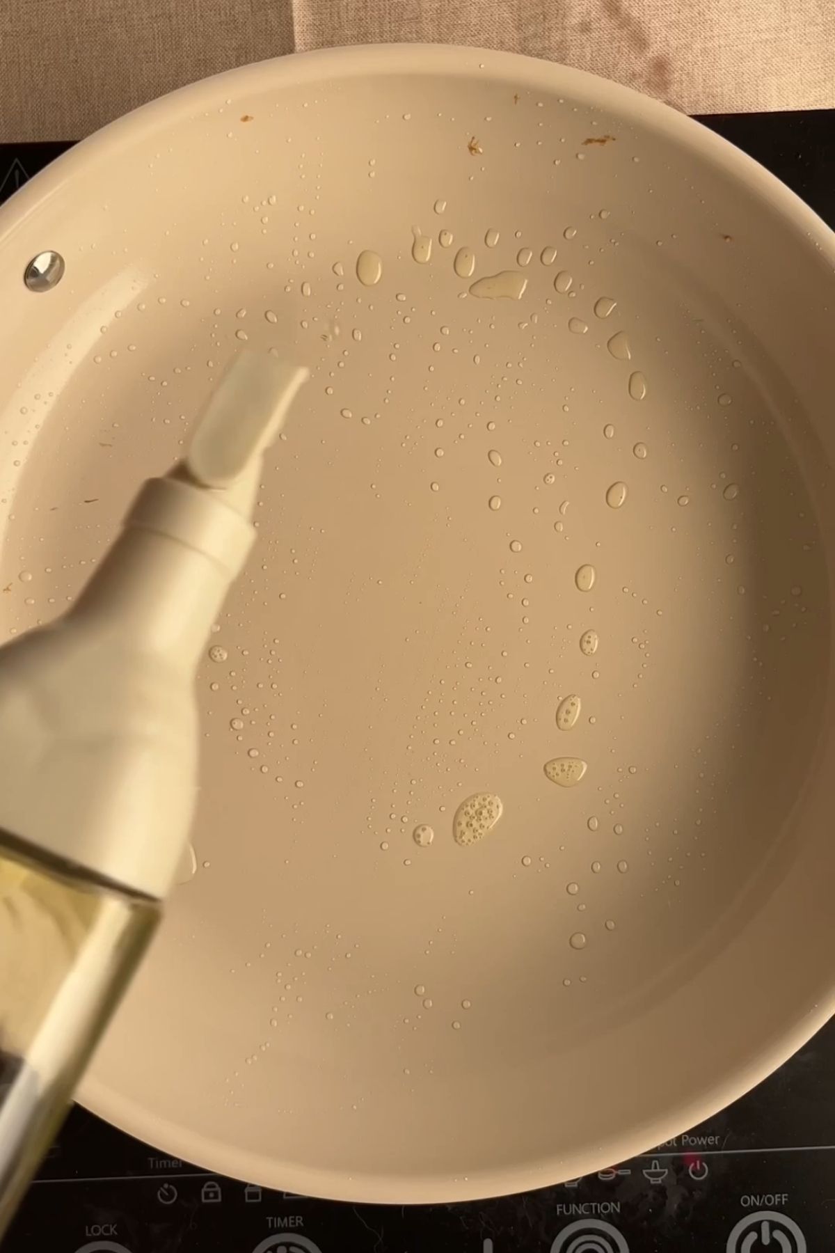 Oil being drizzled into a warm non-stick pan.