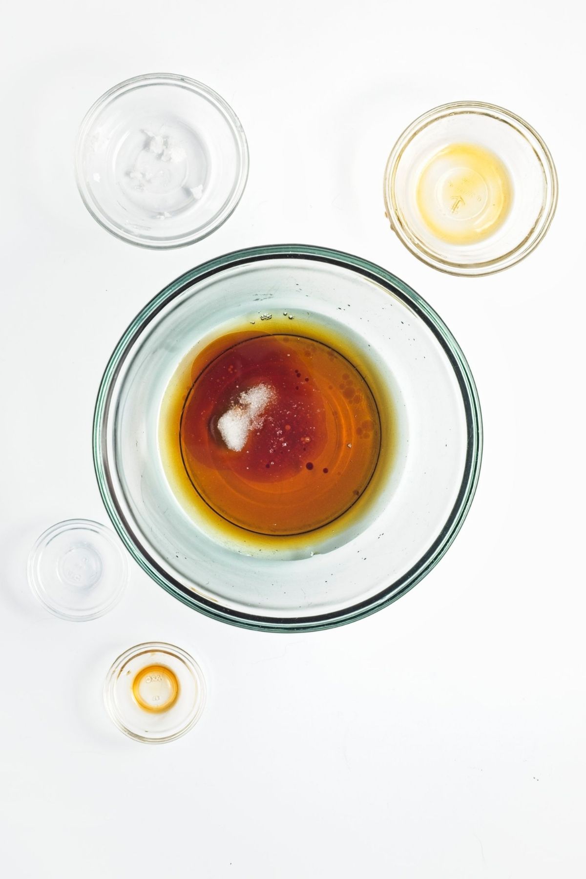 Maple syrup, melted coconut oil, vanilla, and salt combined in a glass bowl.
