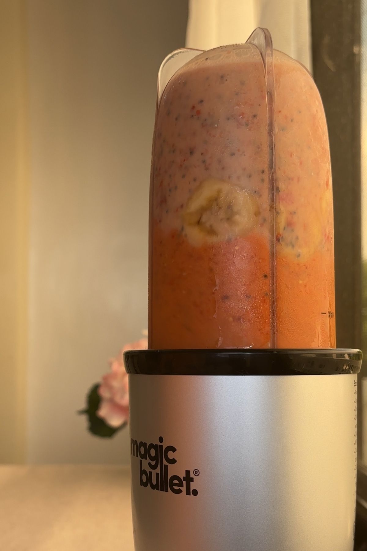 Blender cup filled with fruit, chia seeds, and milk before blending.