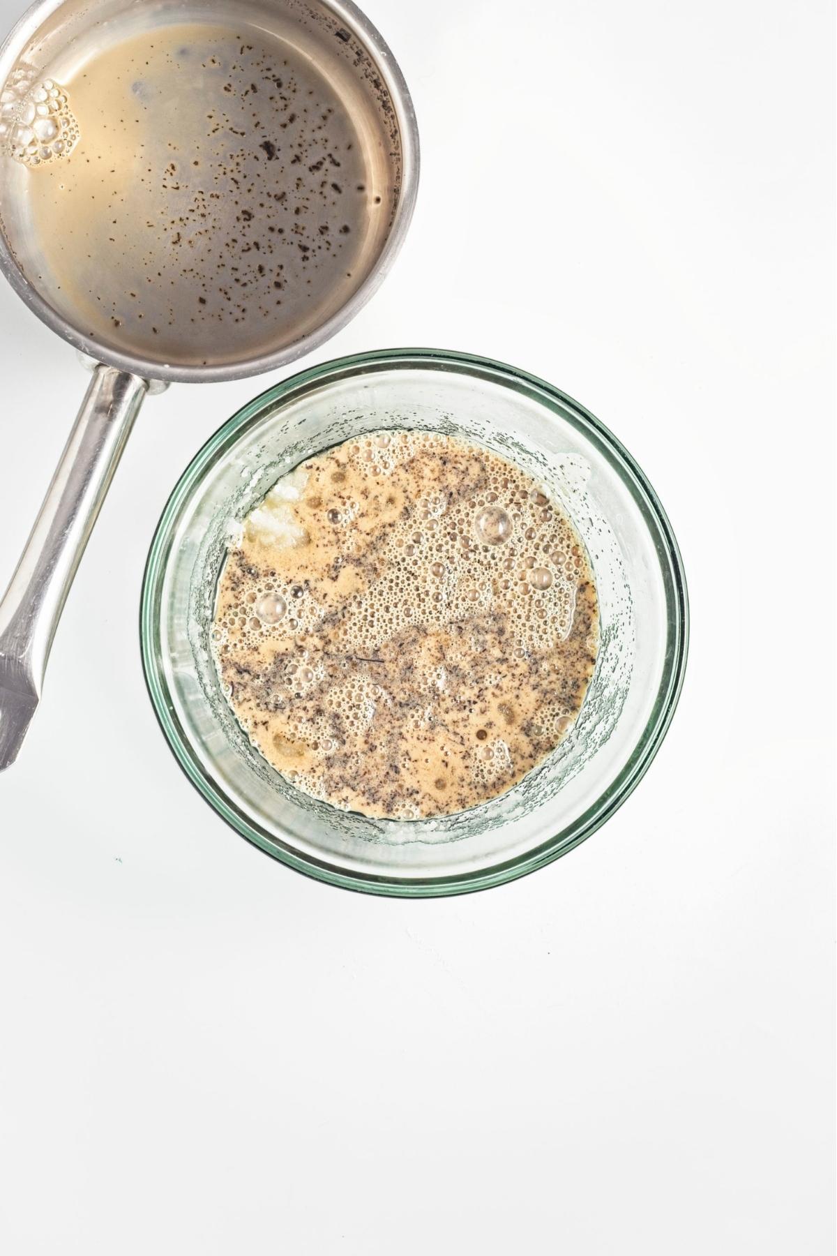 Steeped Earl Grey oat milk poured into a bowl of wet batter with visible tea specks.