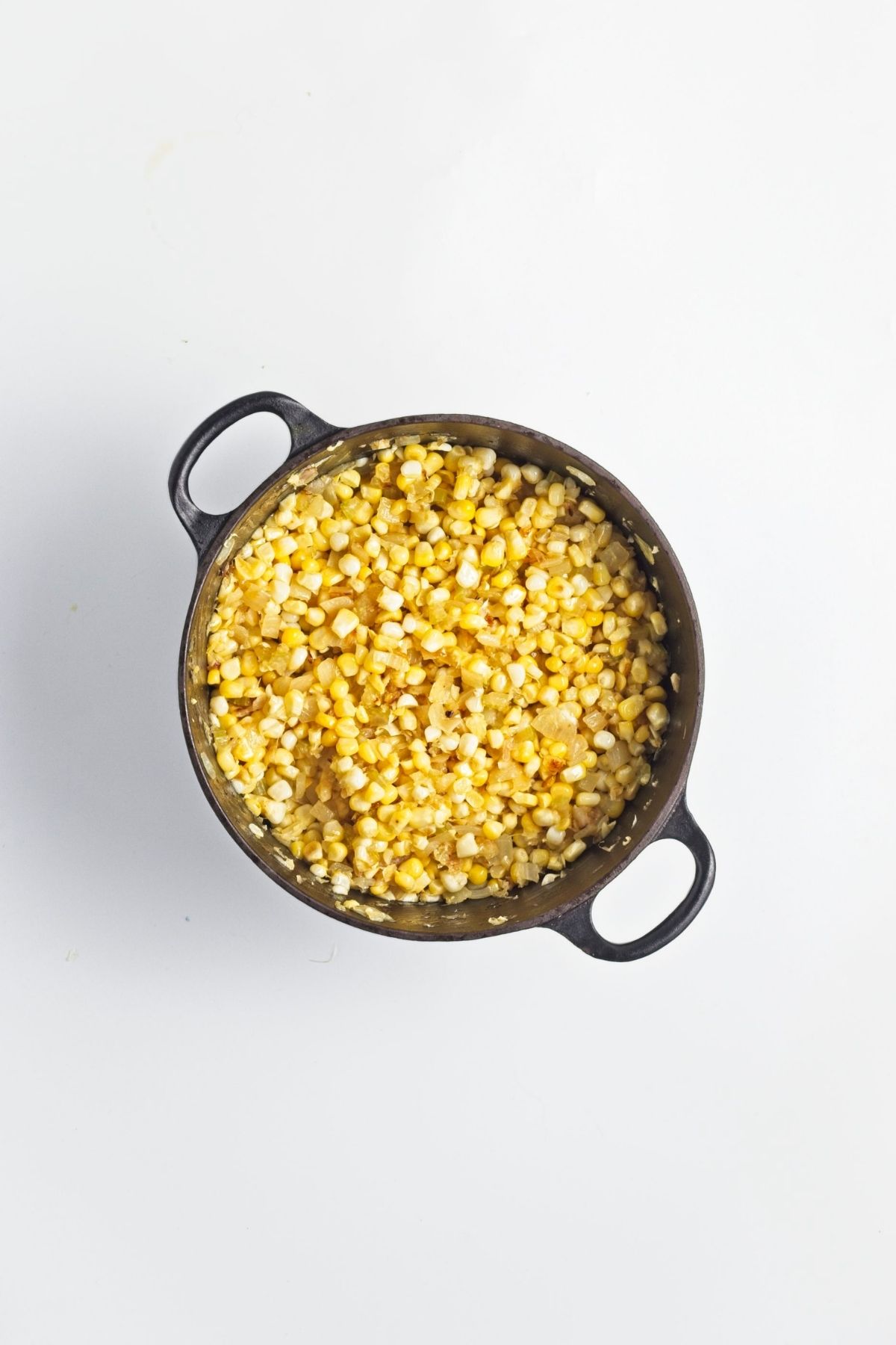 Corn kernels added to the pot with softened onion and celery.