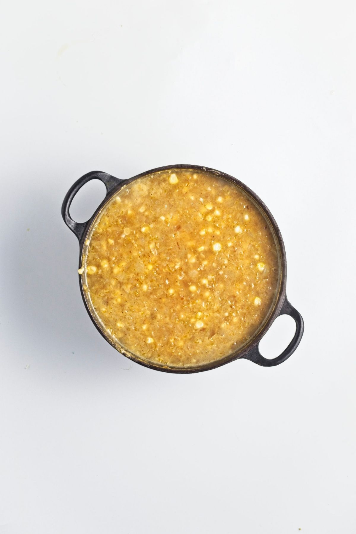 Vegetable broth poured into the pot with corn and miso mixture.