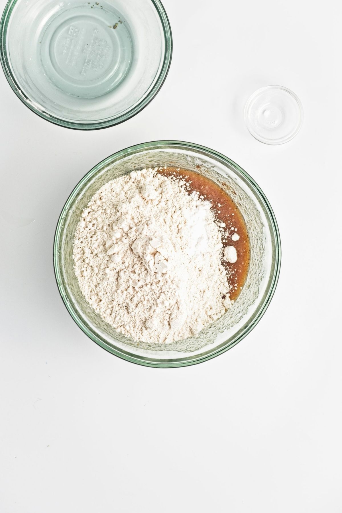 Dry ingredients added to the wet mixture in a glass bowl before stirring.