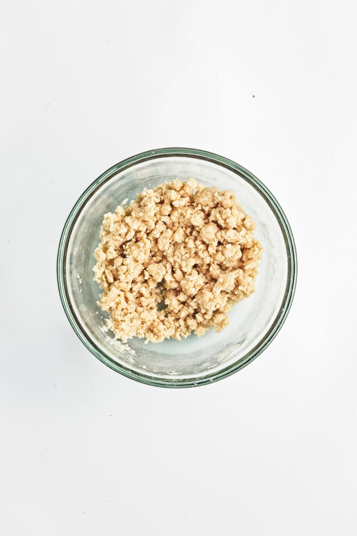 Crumbly pecan pie bar dough in a glass bowl.