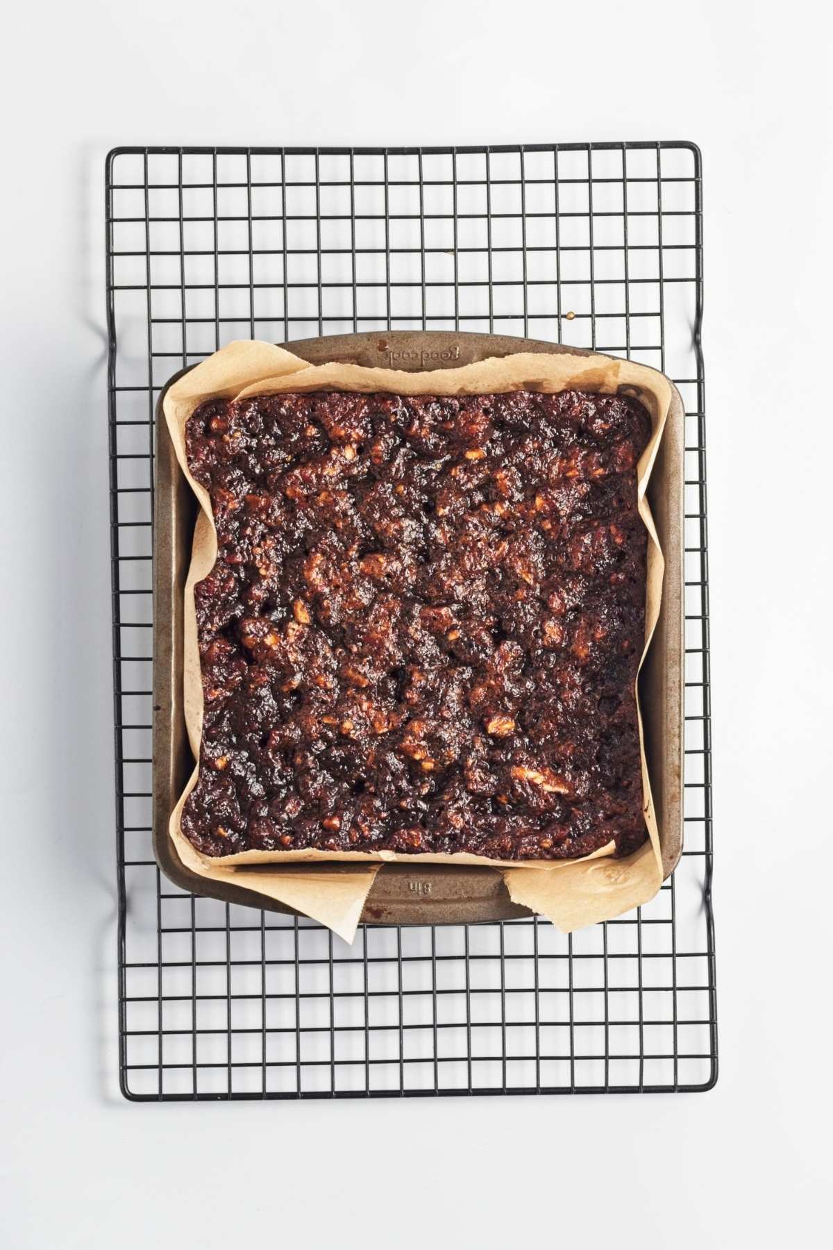 Fully baked pecan slab with a dark, glossy top cooling in the pan.