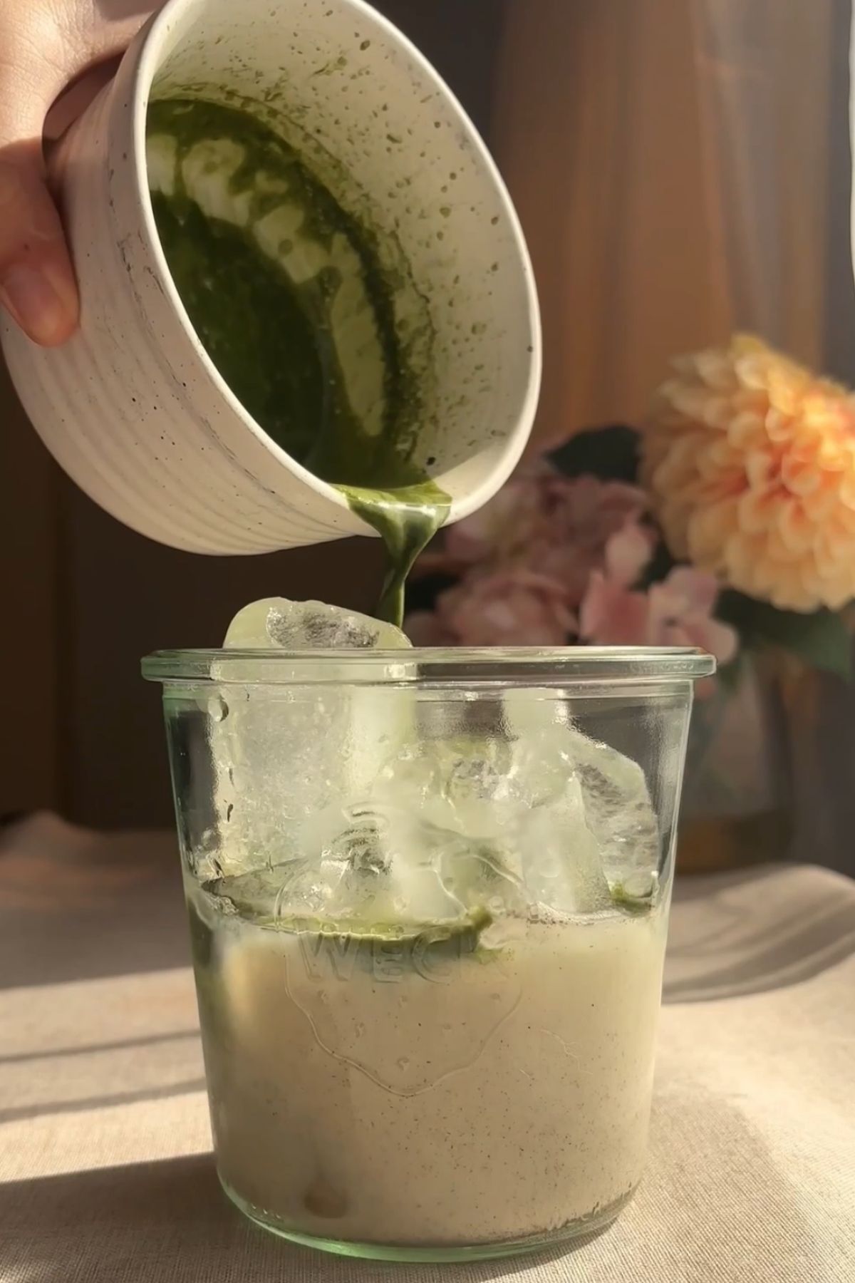Whisked matcha poured over iced milk to create layers.