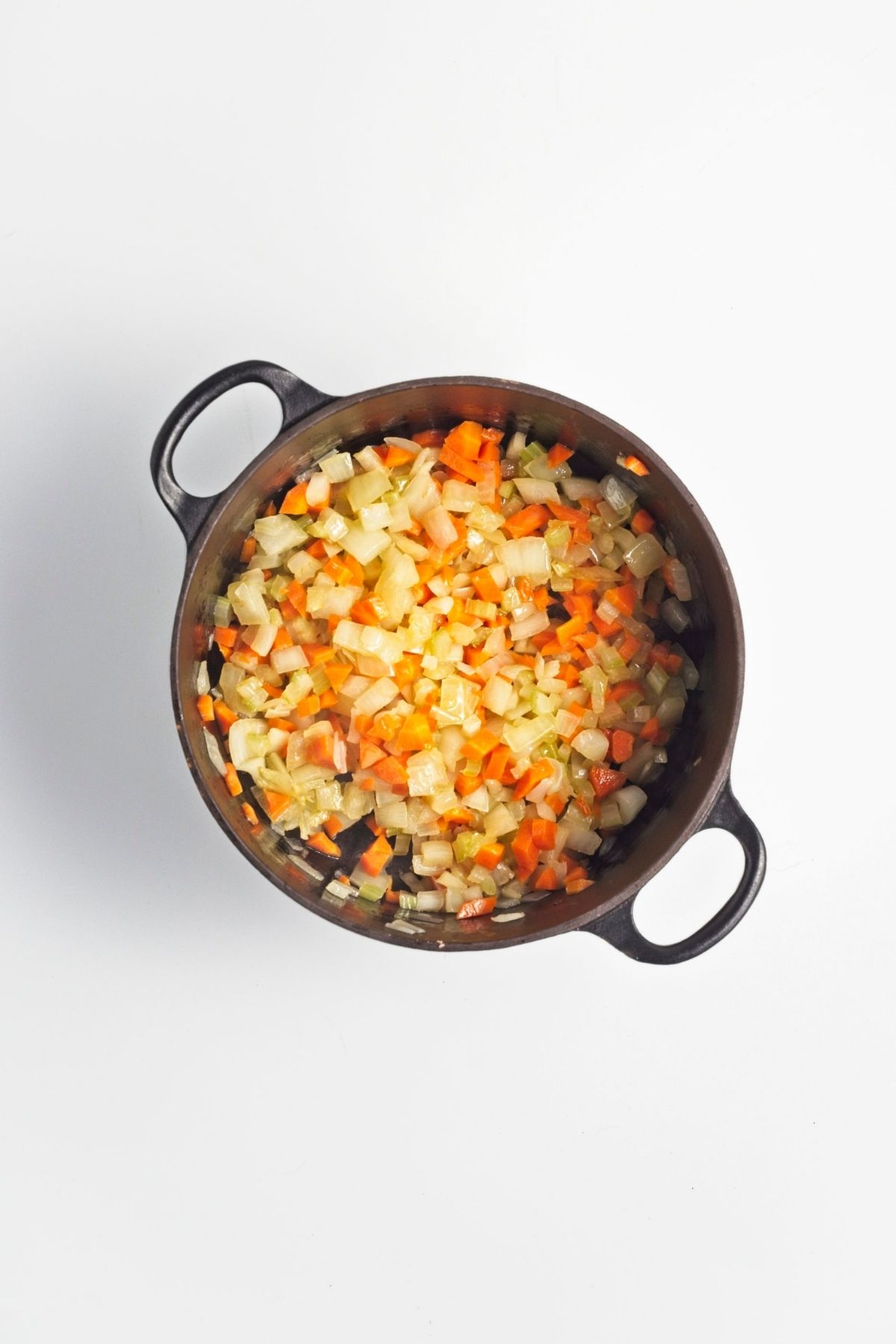 Chopped vegetables cooking in a pot until softened.