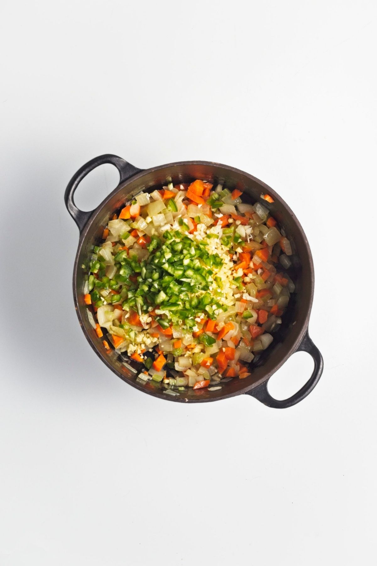 Minced green chili and garlic added to softened vegetables in the pot.