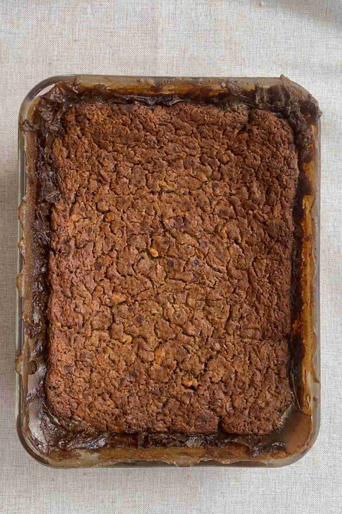 A golden-brown baked oat slab cooling in a rectangular dish.