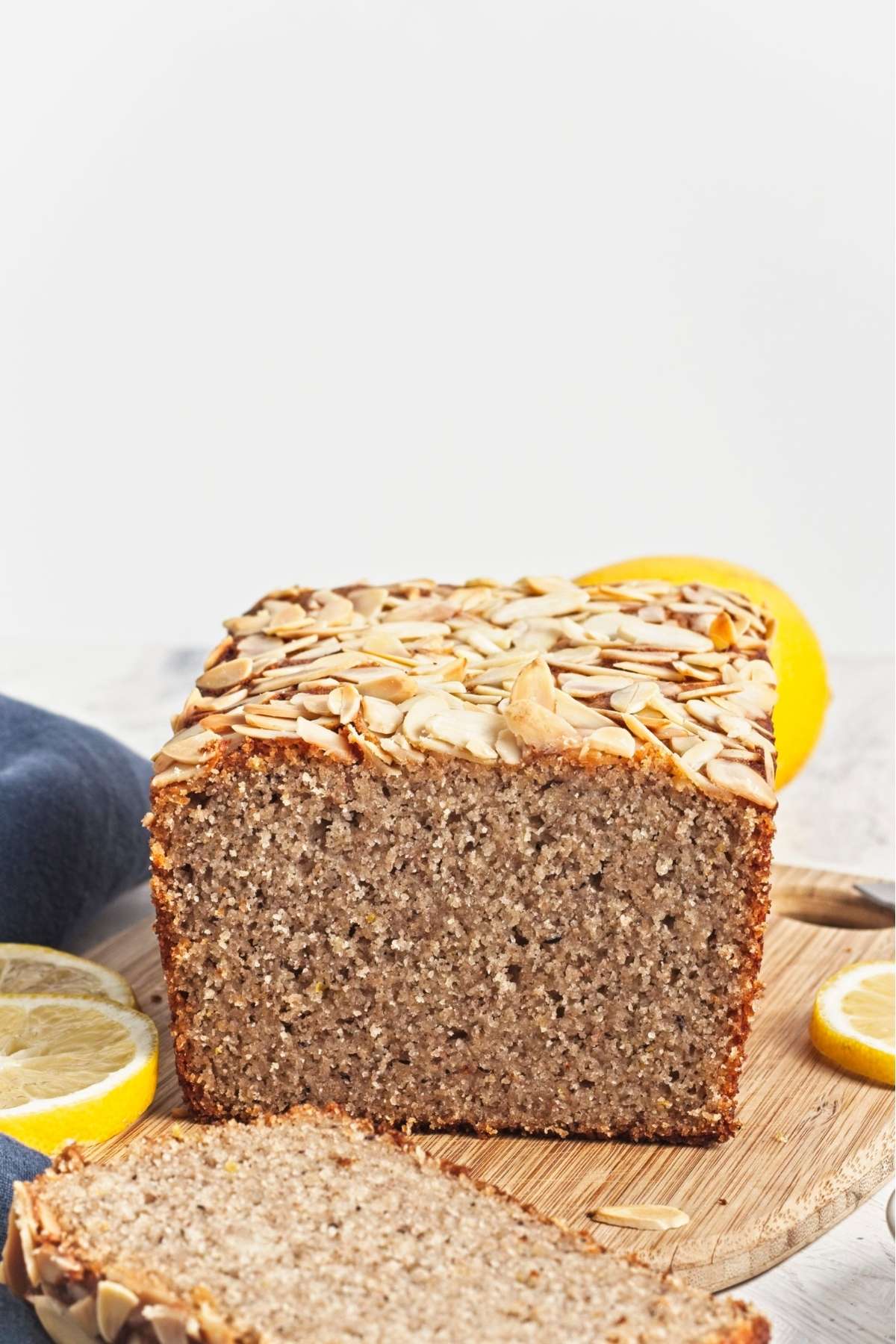 Sliced lemon almond loaf showing a soft, crumbly interior with almonds on top.