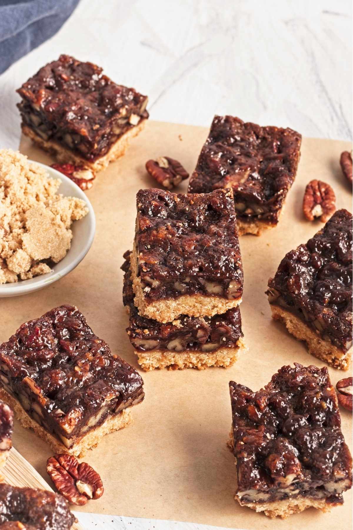 Stacked pecan pie bars showing a thick caramel pecan layer over a golden crust.