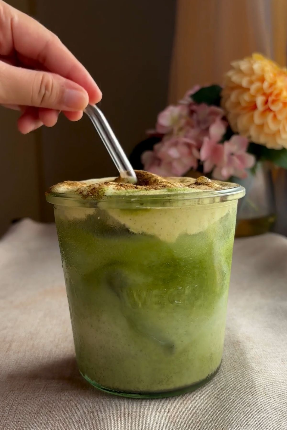Layered iced matcha latte with pale green matcha and creamy pumpkin foam.