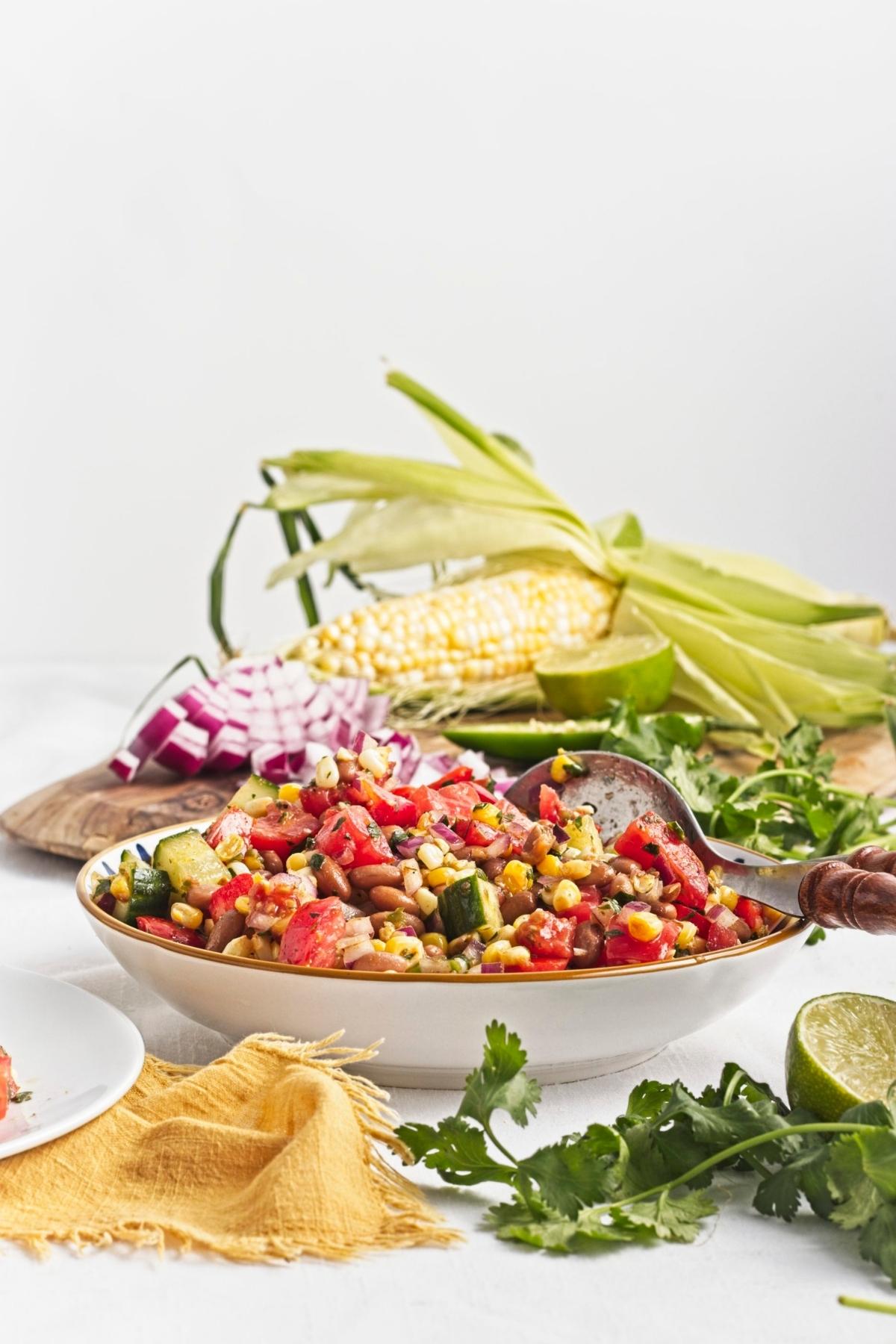 Corn and pinto bean salad plated with rice and lime.