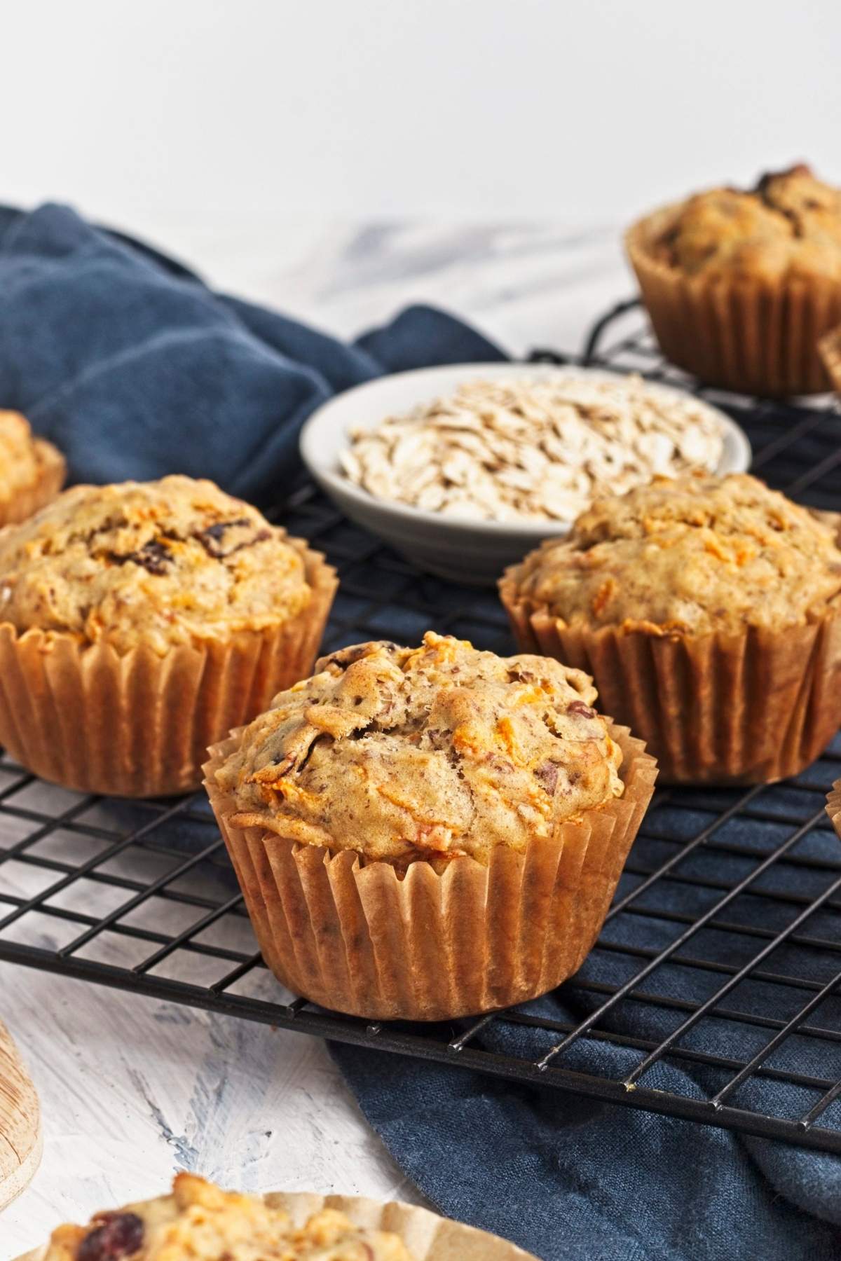 Freshly baked vegan carrot cake muffins cooling on a wire rack with golden domed tops