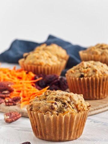 Close-up of vegan carrot cake muffins showing textured tops and paper liners