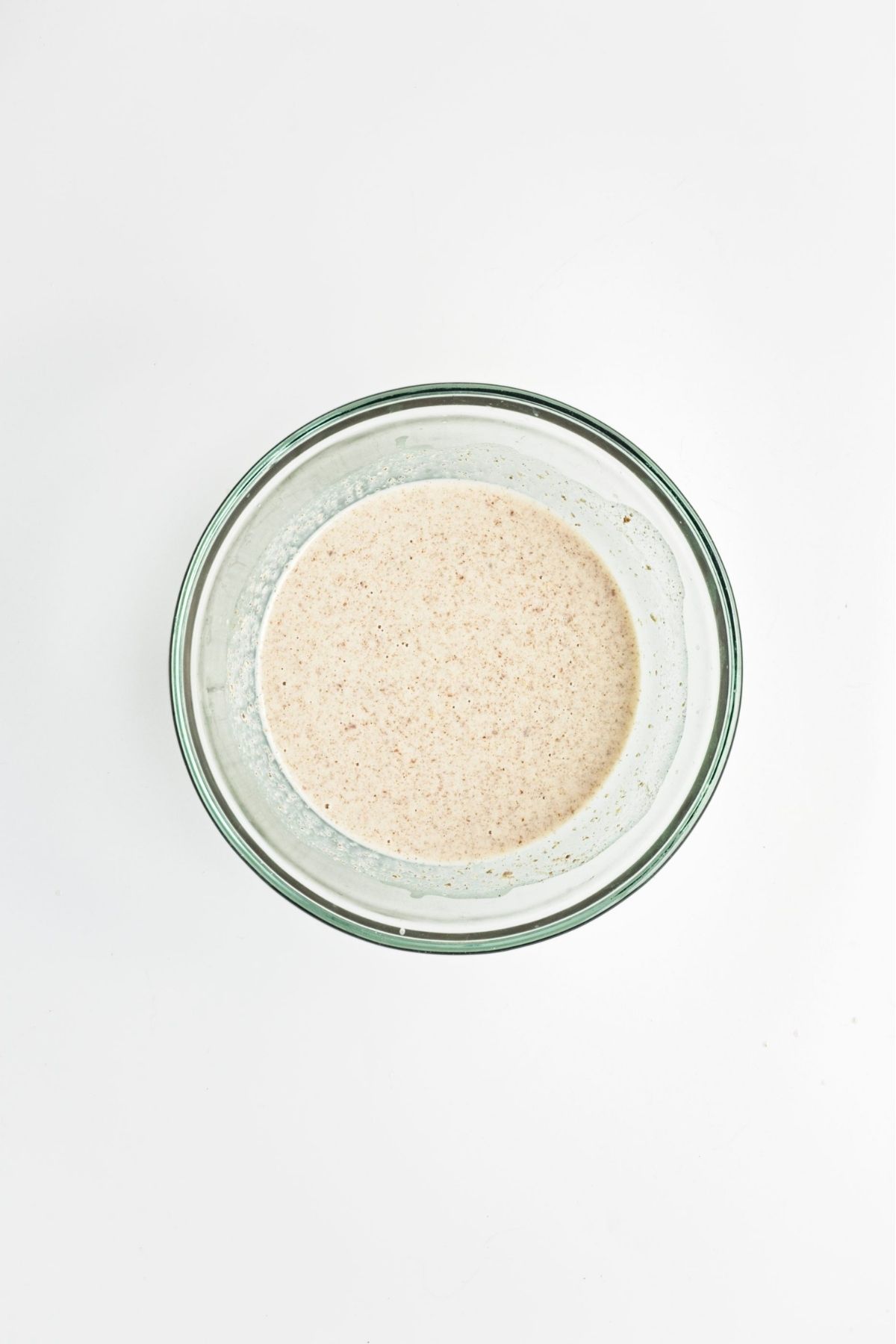 Ground flax mixed with oat milk in a bowl to create flax egg mixture
