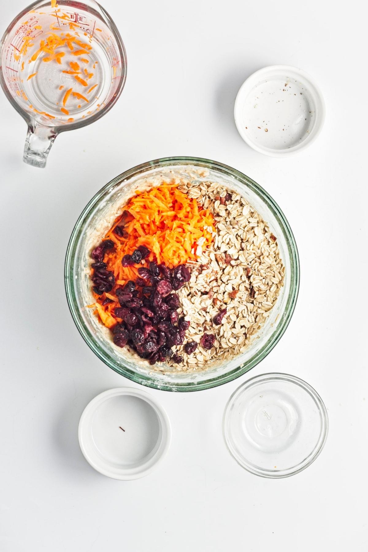 Shredded carrot oats nuts and dried fruit added to muffin batter