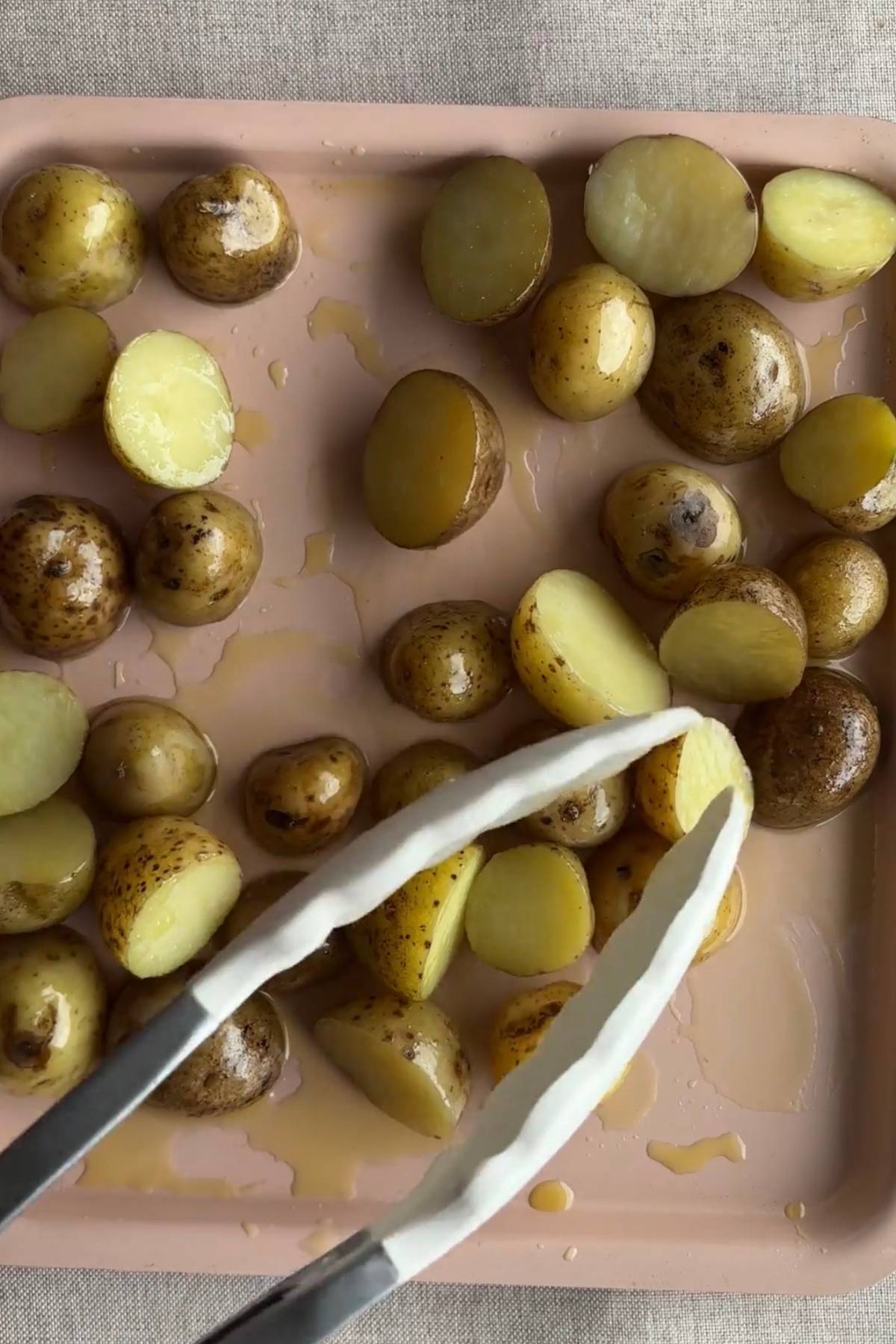 Cooked baby potatoes crisping in olive oil for added texture