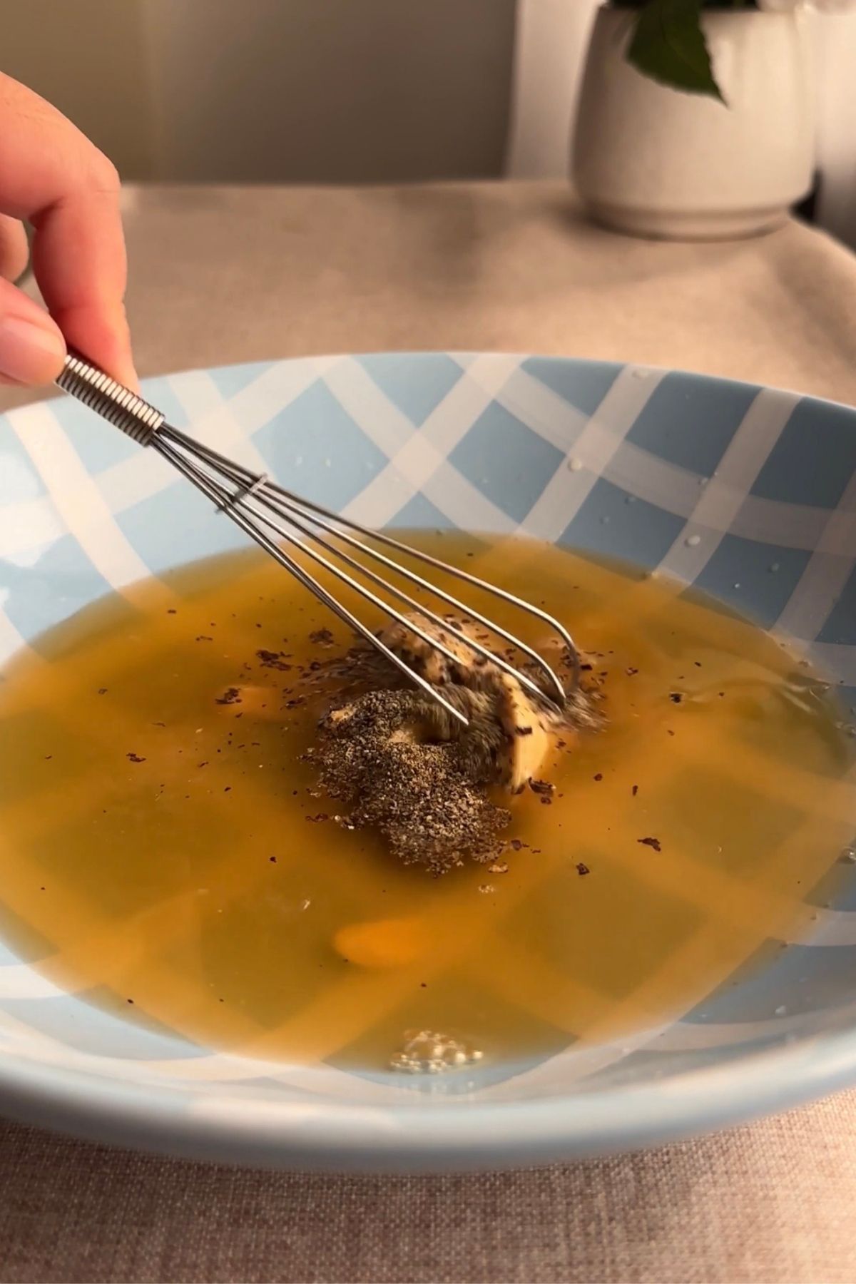 Whisking the dressing to combine all the herbs and flavours.