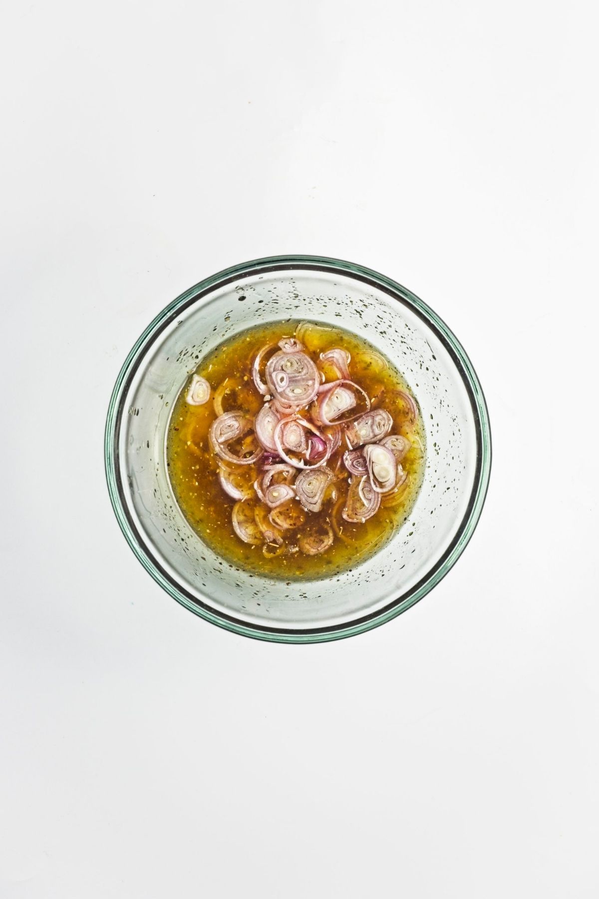 Sliced peaches and tomatoes tossed together in a glass bowl.