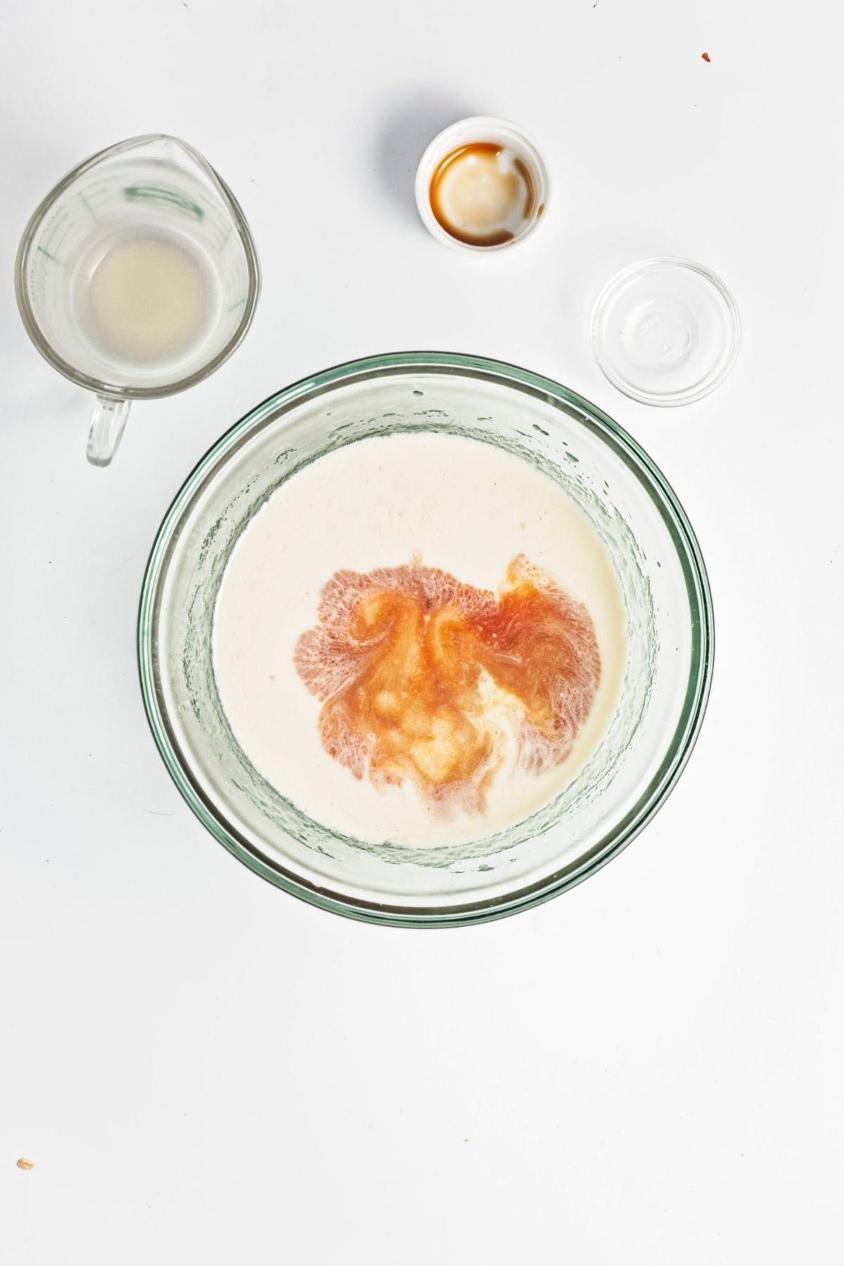 Wet ingredients mixed in a bowl with oat milk, applesauce, oil, vanilla, and vinegar.
