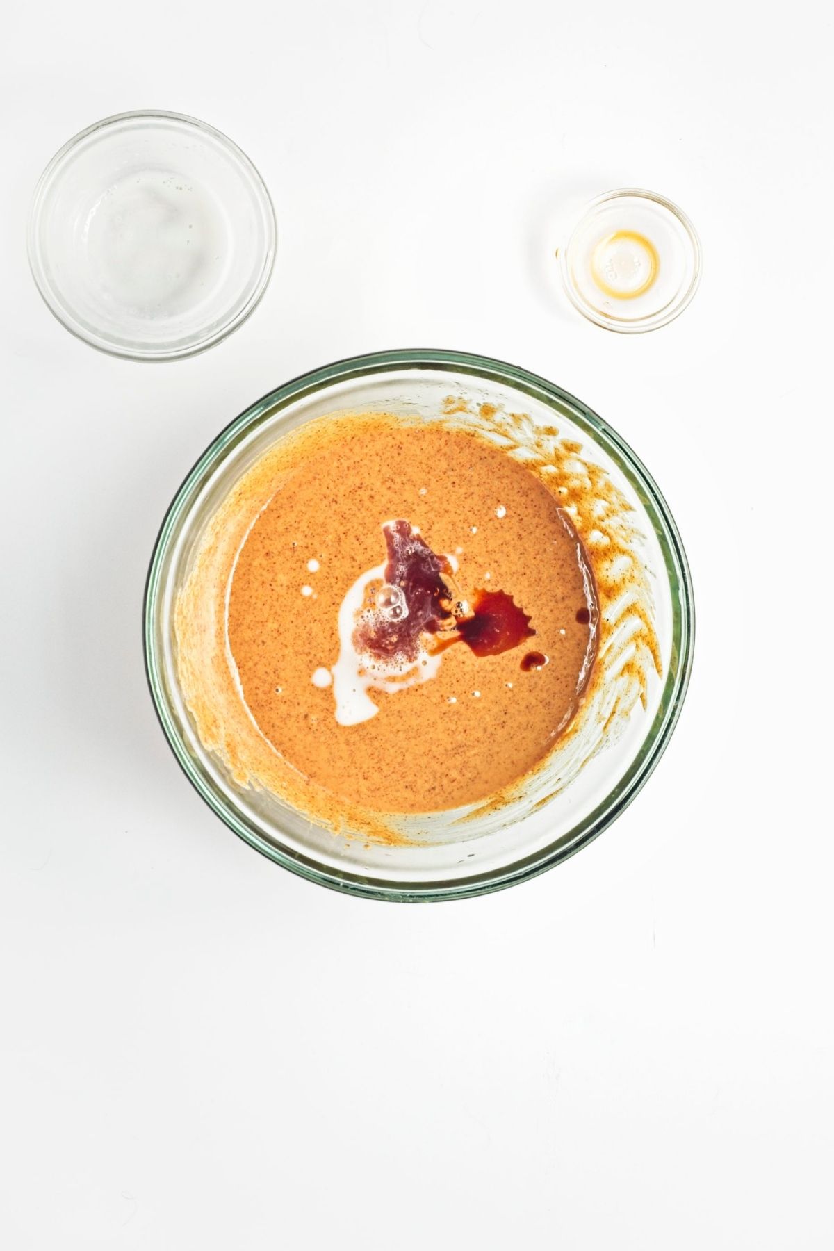 Almond butter and oil mixed together in a glass bowl
