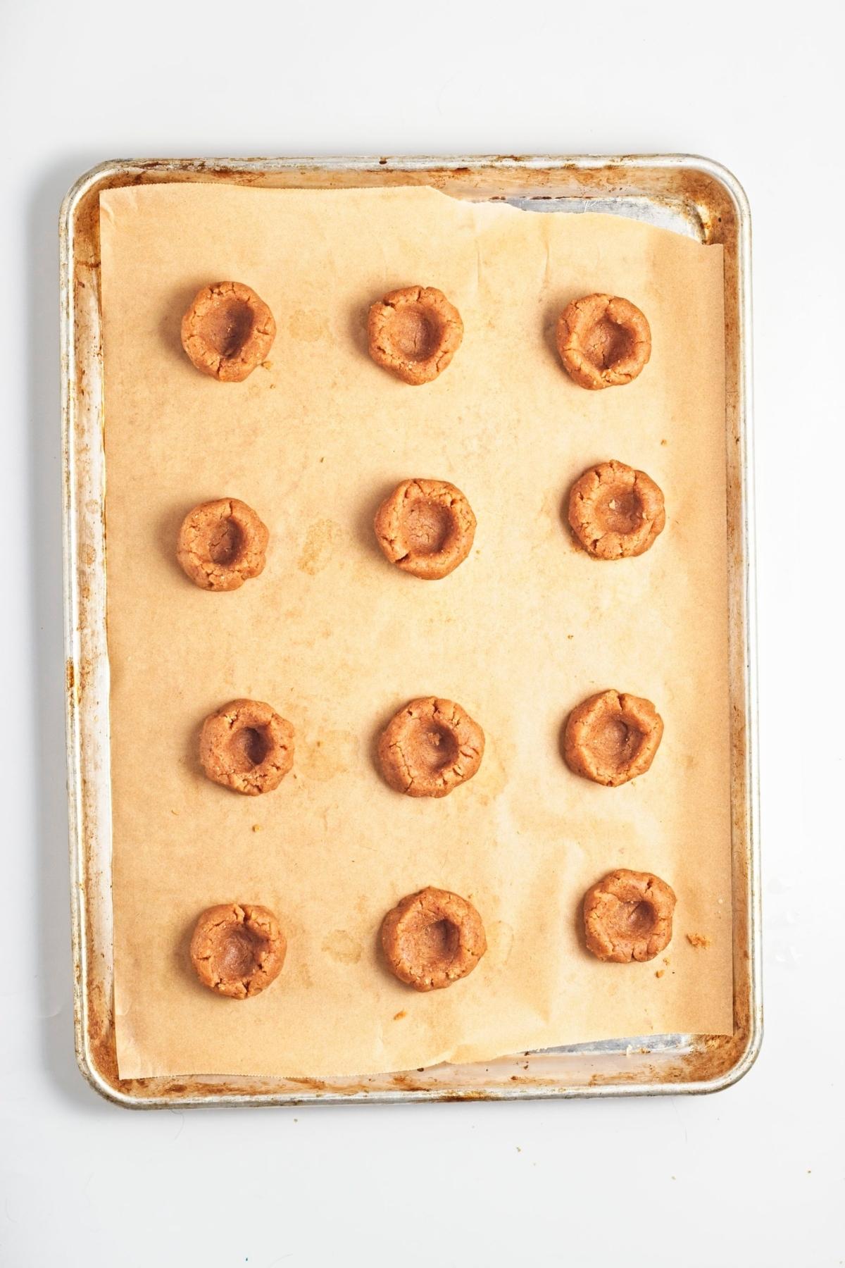 Thumbprints pressed into cookie dough balls before filling