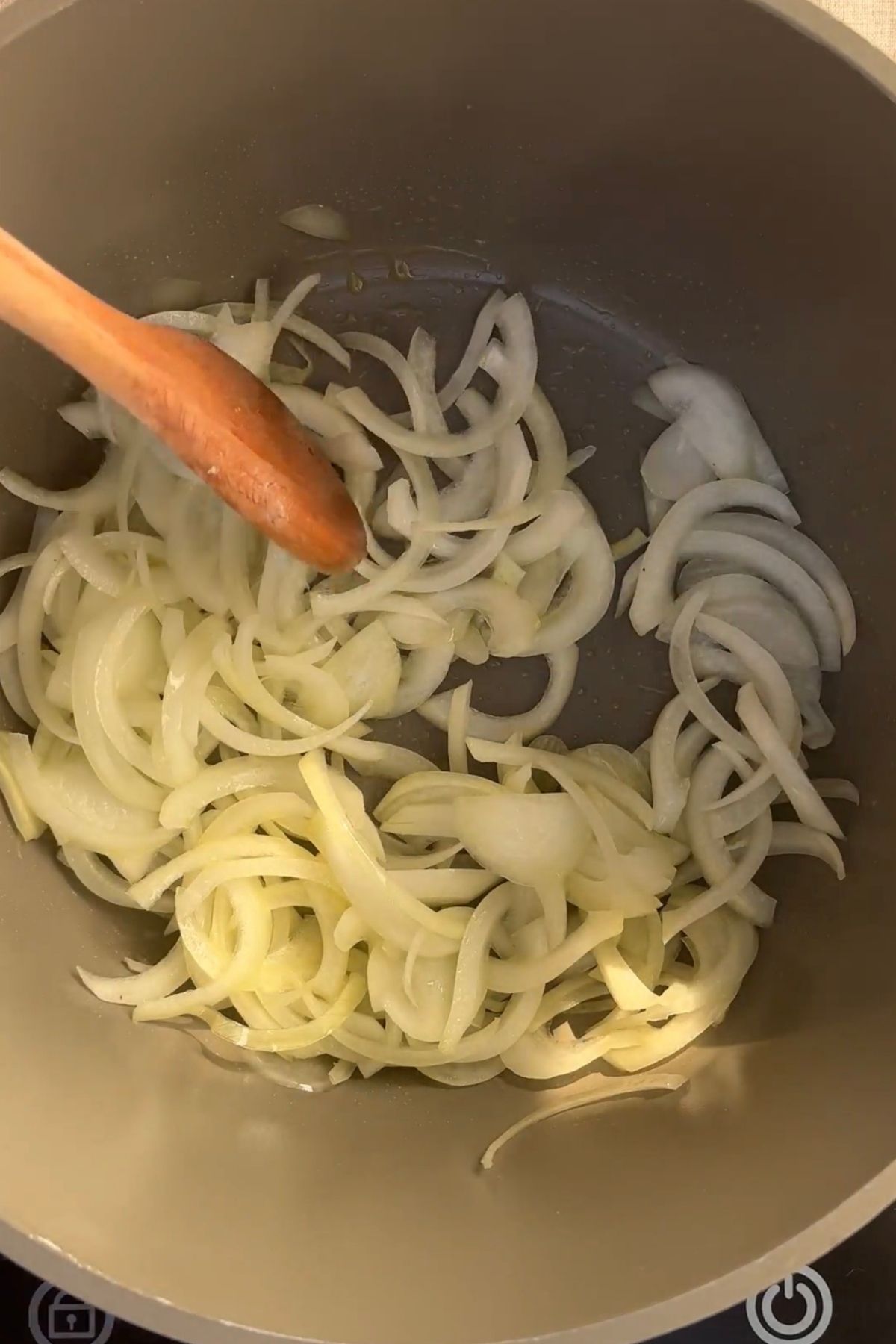 Sliced onion cooking in olive oil in a large pot until softened and lightly golden.