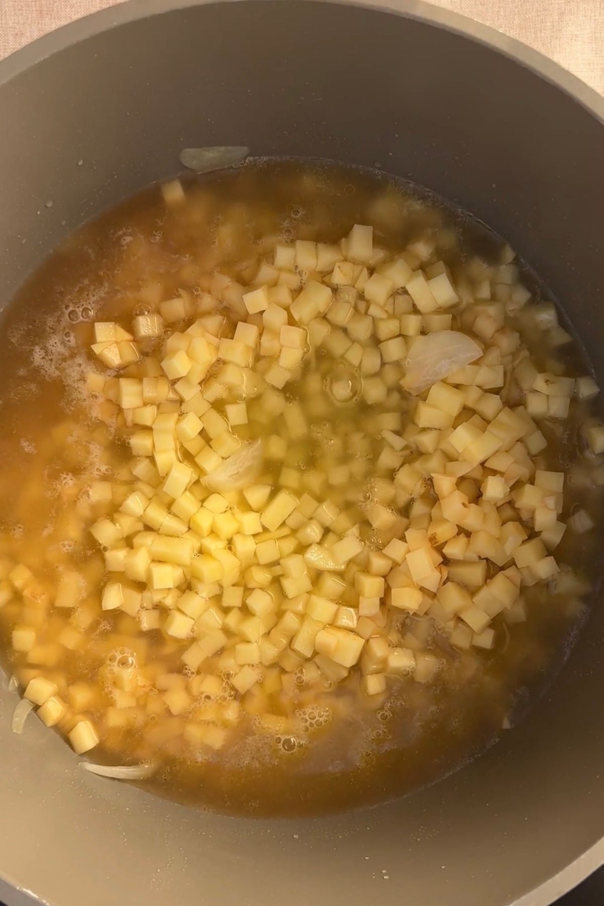 Diced potatoes added to the pot with sautรฉed onions and vegetable broth.