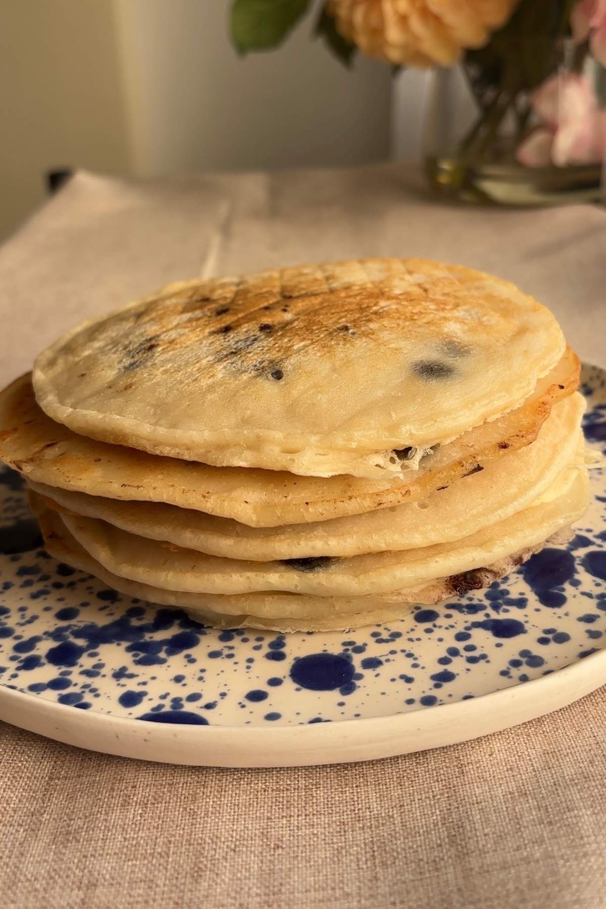 Stack of cooked pancakes resting on a plate before serving.