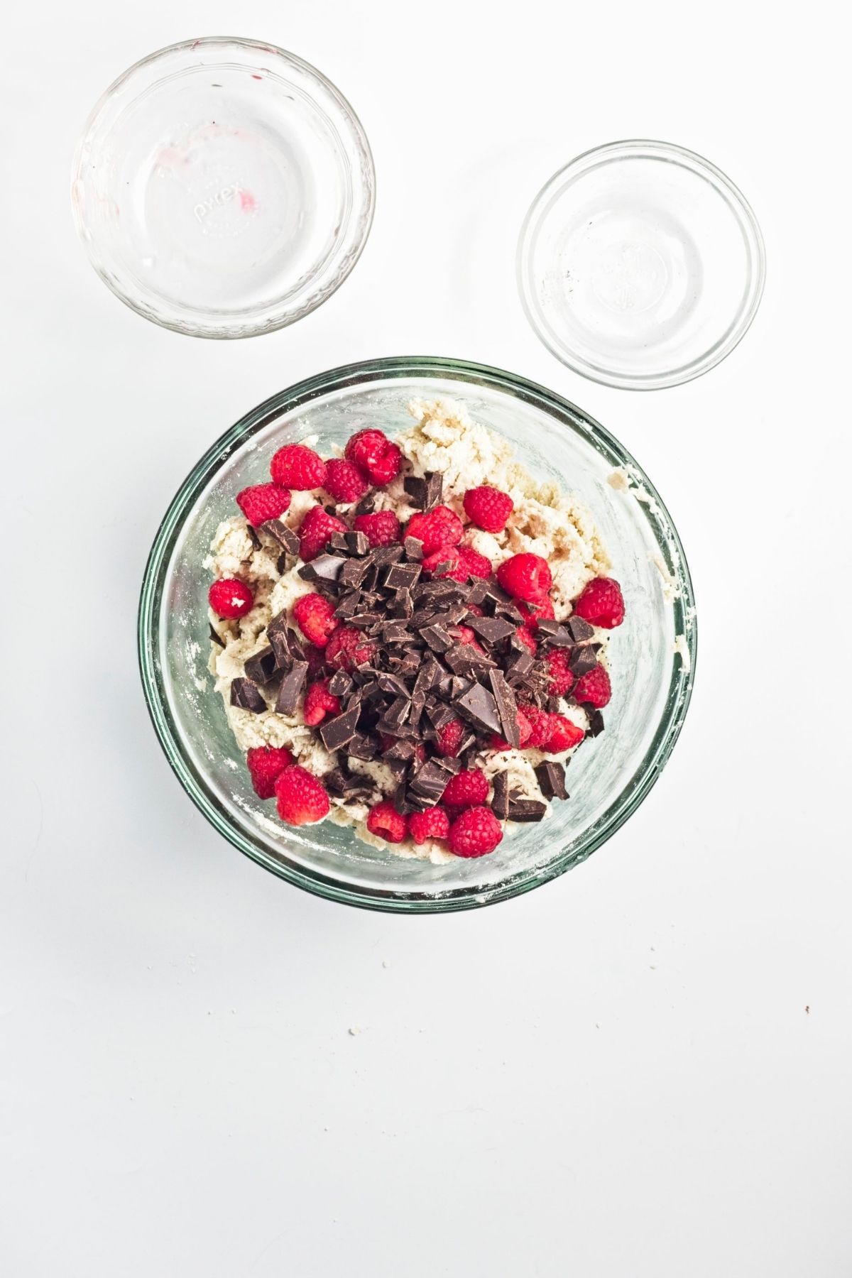 Scone dough topped with fresh raspberries and chopped dark chocolate.
