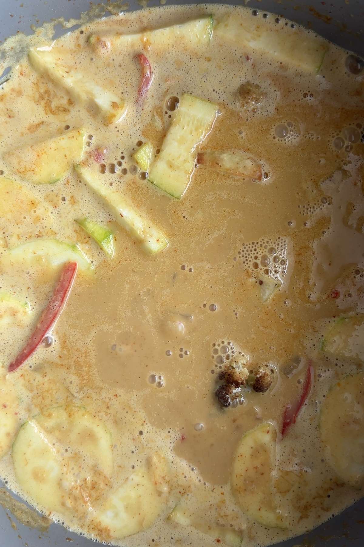 Vegetables simmering in creamy yellow curry sauce.