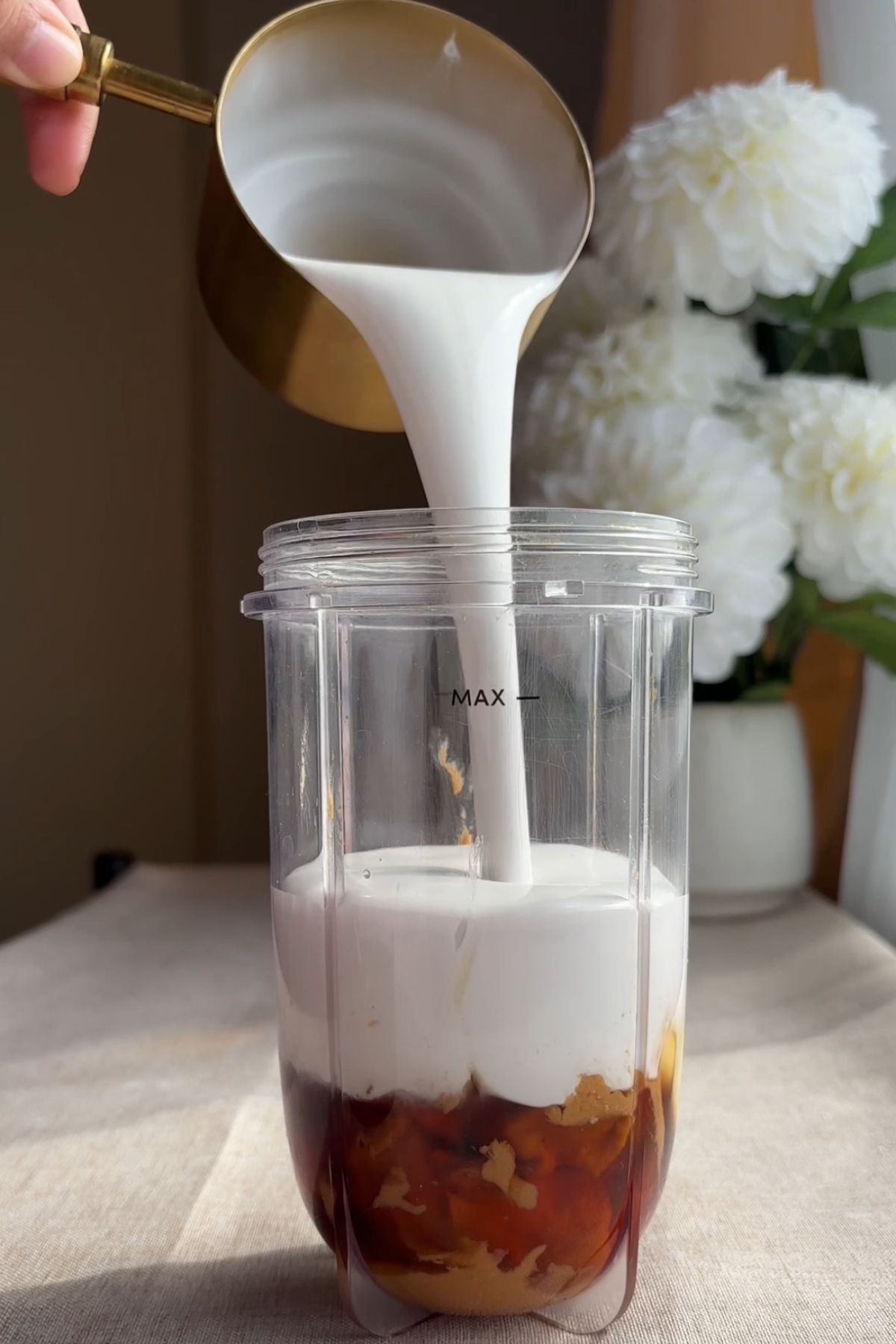 Coconut milk, maple syrup, and nut butter added to a blender to make vegan ice cream bar filling