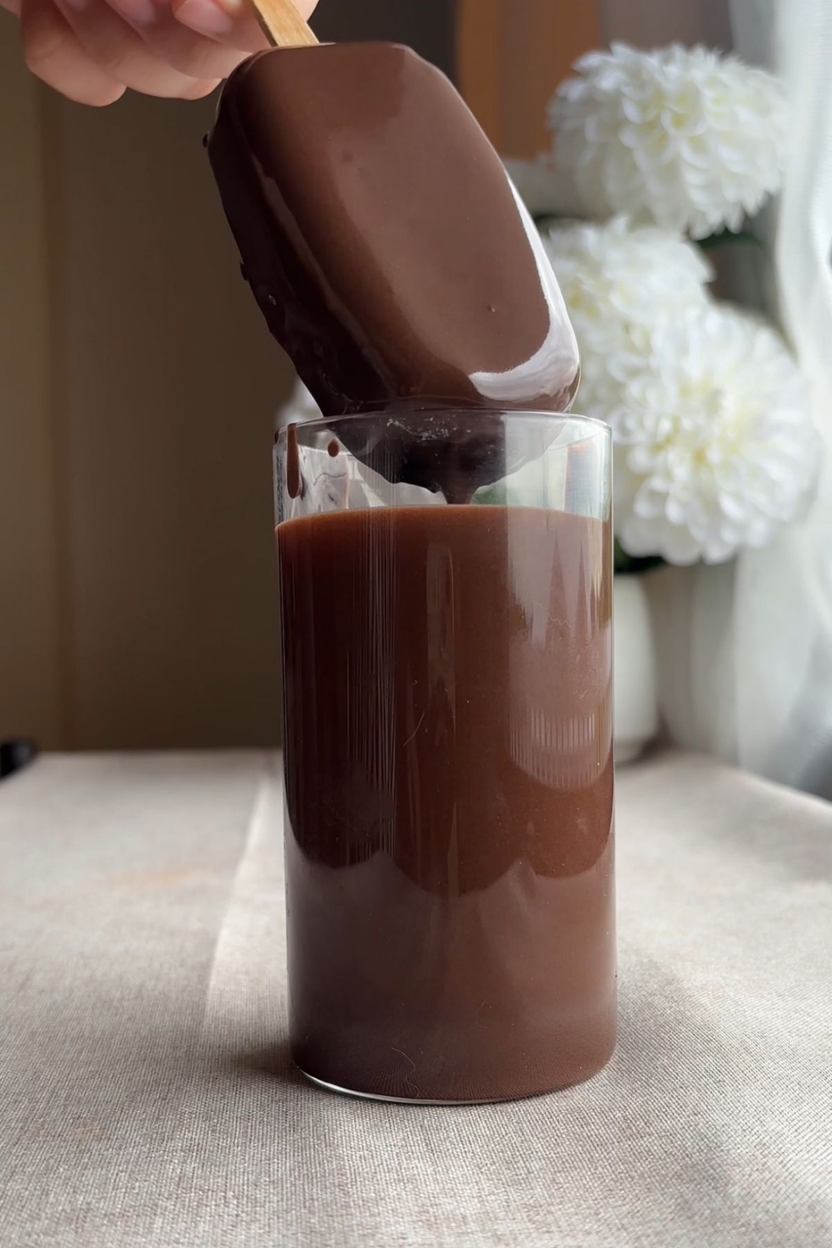 Frozen vegan ice cream bars coated in melted dark chocolate mixed with coconut oil