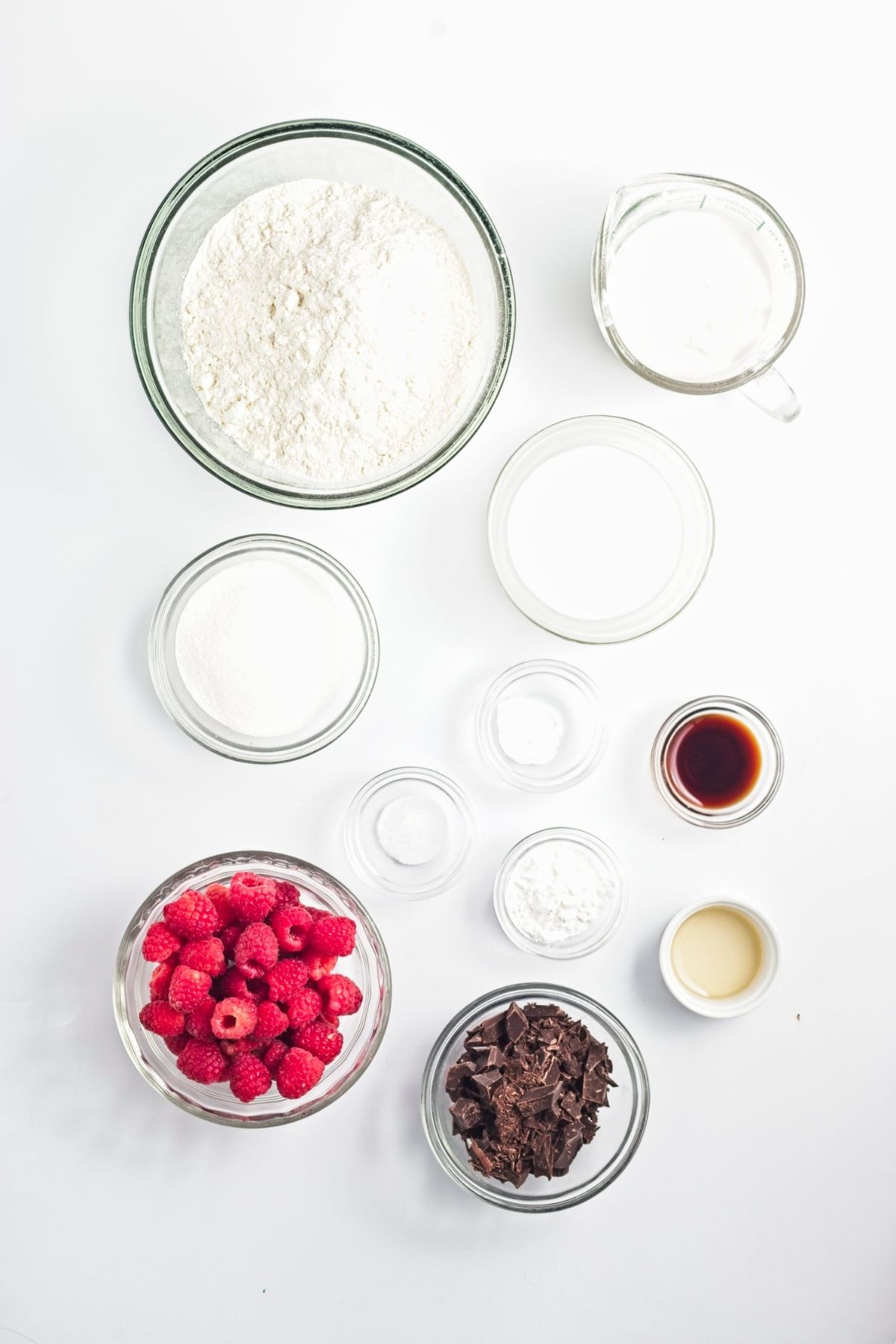Measured flour, sugar, raspberries, chopped chocolate, and baking ingredients.