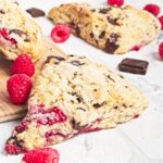 Close-up of a scone showing jammy raspberries and melted dark chocolate inside.