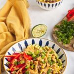 Brown rice bowl with corn, pinto beans, avocado, red bell pepper, and chipotle dressing