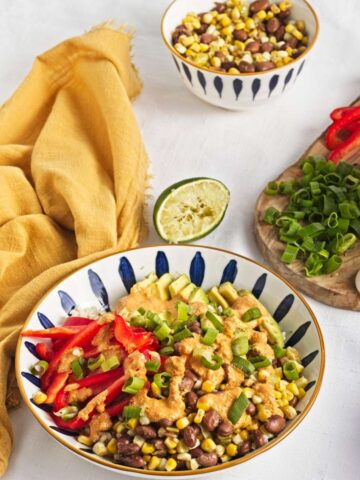 Brown rice bowl with corn, pinto beans, avocado, red bell pepper, and chipotle dressing