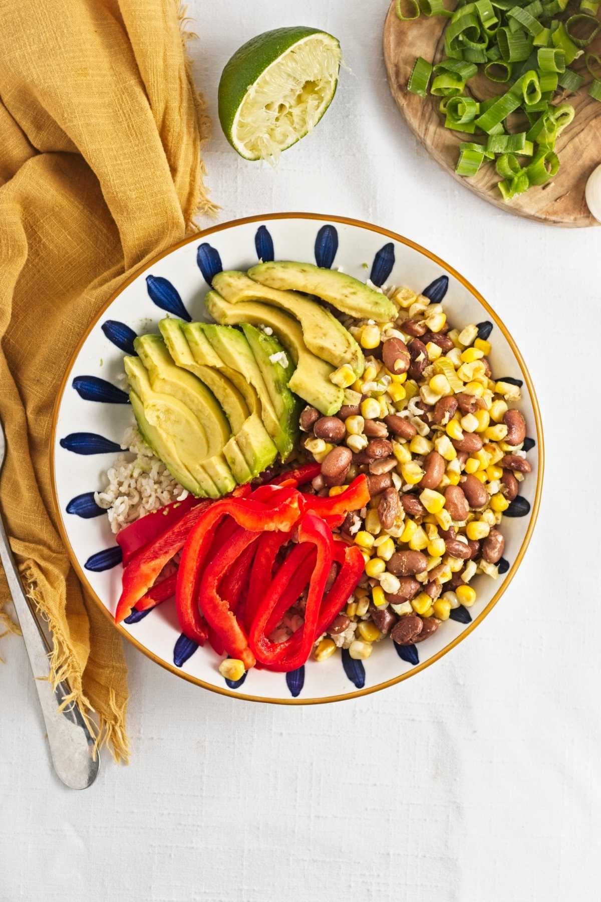 Cooked brown rice, pinto beans, corn, avocado, red pepper, sunflower seeds, spices, and lime