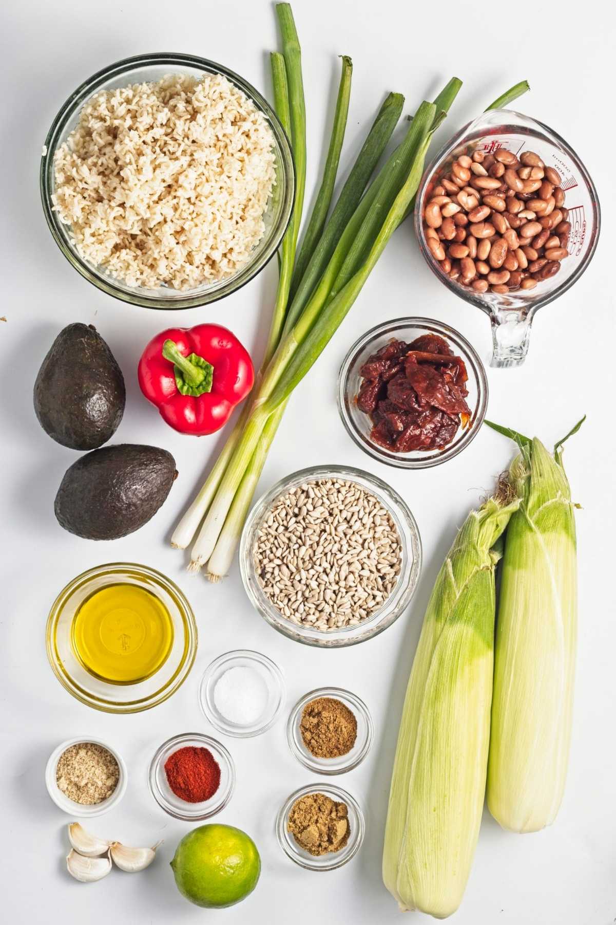 Corn, pinto beans, brown rice, avocado, red bell pepper, green onions, sunflower seeds, olive oil, spices, and lime