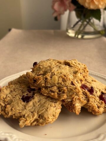 Oat cranberry cookies stacked on a white plate.