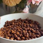 Crispy roasted chickpeas scattered across a shallow white bowl.
