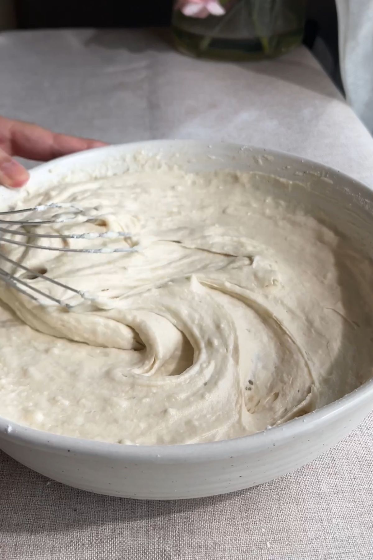 Cupcake batter mixed in a large bowl with a whisk.