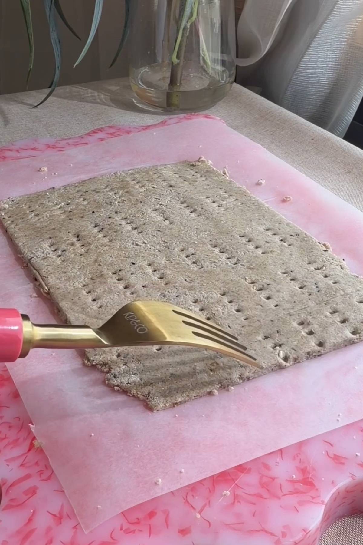 Rolled cracker dough on parchment, pricked all over with a fork.